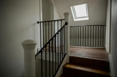 a stairway with a black railing and a window at Tower Square House in Alloa