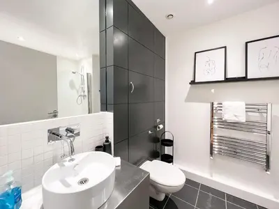 a white bathroom with a sink and a toilet at Lovely 2 Bed Duplex Apartment with Hydro Views in Glasgow