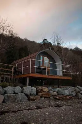 a small house on top of a pile of rocks at The Boathouse pod in Onich