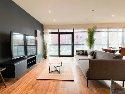a living room with a couch and a flat screen tv at Lovely two bed apartment in Finnieston in Glasgow