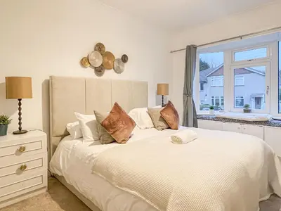 a bedroom with a large white bed with a window at Attractive 3 Bedroom Apartment in Polmadie
