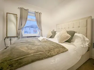 a bedroom with a large bed with a large window at Attractive 3 Bedroom Apartment in Polmadie