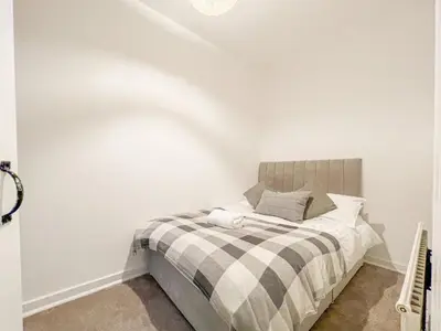 a bedroom with a bed in a white wall at Attractive 3 Bedroom Apartment in Polmadie