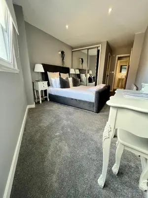 a bedroom with a bed and a large mirror at Glas Go Executive 2-Bedroom Apartment near OVO Hydro Free Parking in Glasgow