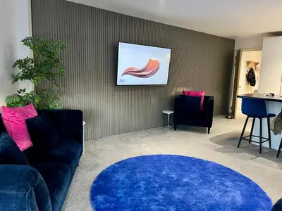 a living room with a blue couch and a blue rug at Glas Go Executive 2-Bedroom Apartment near OVO Hydro Free Parking in Glasgow
