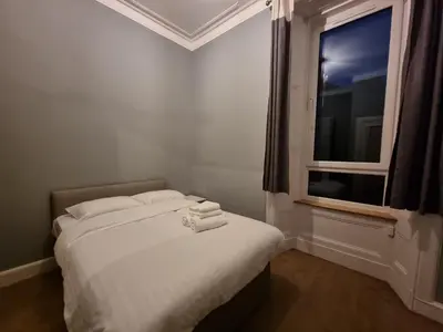 a small bedroom with a bed with a window at Bright 3 Bedroom Edinburgh City Apt in Edinburgh
