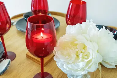 a table with three red wine glasses and a candle at Modern 1BR flat - free parking + lift in Edinburgh