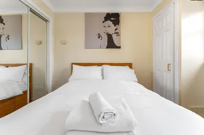 a bedroom with a white bed with towels on it at Modern 1BR flat - free parking + lift in Edinburgh