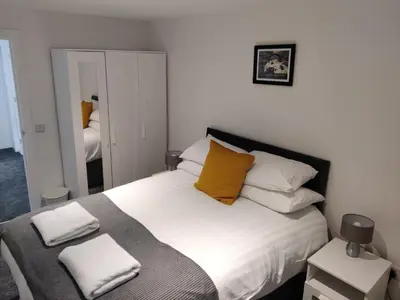 a bedroom with a large white bed with yellow pillows at No 7 Westbay Apartment in Oban