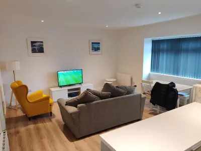 a living room with a couch and a television at No 7 Westbay Apartment in Oban