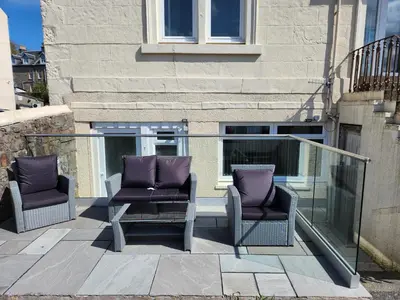 two chairs and a table on a balcony at No 7 Westbay Apartment in Oban