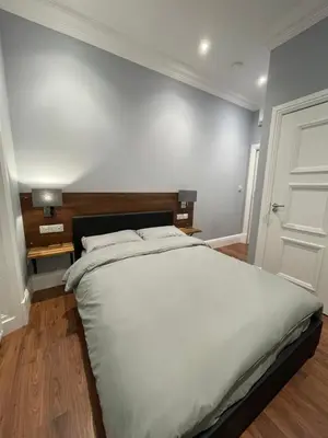 a bedroom with a large white bed and a door at Laurieston Inn in Falkirk