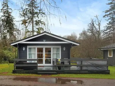 a small house with a porch and a window at Loch Lomond Sanctuary Lodges in Balloch
