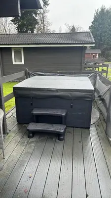 a bed sitting on top of a wooden deck at Loch Lomond Sanctuary Lodges in Balloch