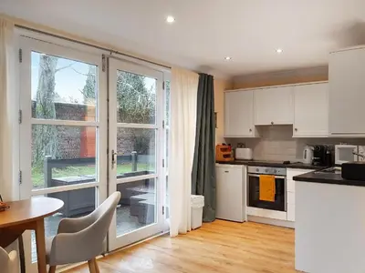 a kitchen with white cabinets and a table and a window at Loch Lomond Sanctuary Lodges in Balloch