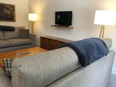 a living room with a couch and a tv at Glenheurie Cottage in Polmood