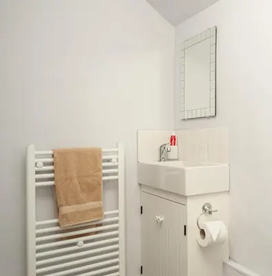 a white bathroom with a sink and a mirror at The Distillers Den in Oban
