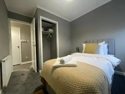 a bedroom with a bed with a towel on it at Dunbeth House in Coatbridge