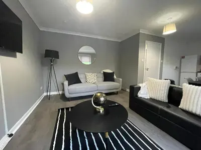 a living room with a couch and a table at Dunbeth House in Coatbridge