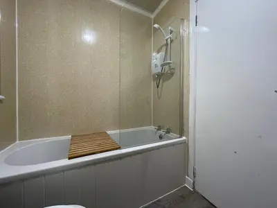 a bathroom with a bath tub with a shower at Dunbeth House in Coatbridge