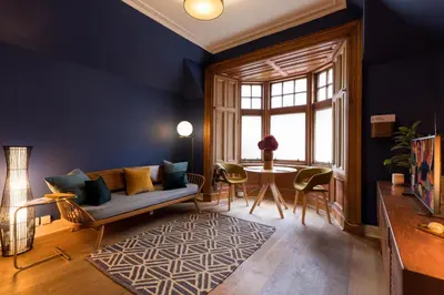 a living room with a couch and a table at JOIVY Contemporary Cottage with Free Parking in Edinburgh