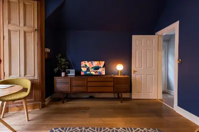 a room with a desk and a blue wall at JOIVY Contemporary Cottage with Free Parking in Edinburgh
