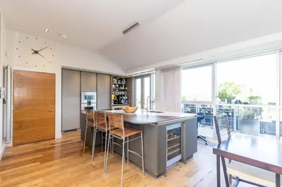a kitchen with a large island with bar stools at JOIVY Beautiful Penthouse with Terrace & Jacuzzi in Edinburgh
