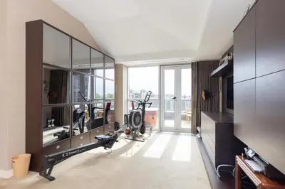 a gym with exercise equipment and a large window at JOIVY Beautiful Penthouse with Terrace & Jacuzzi in Edinburgh