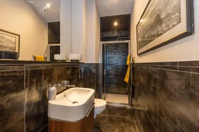 a bathroom with a sink and a toilet at JOIVY Beautiful Penthouse with Terrace & Jacuzzi in Edinburgh