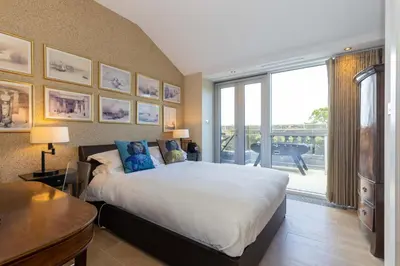 a bedroom with a large bed and a large window at JOIVY Beautiful Penthouse with Terrace & Jacuzzi in Edinburgh