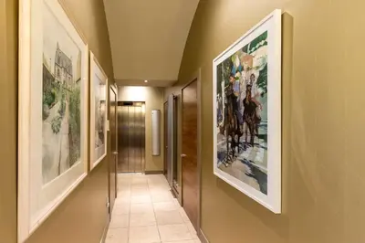 a hallway with paintings on the walls at JOIVY Beautiful Penthouse with Terrace & Jacuzzi in Edinburgh