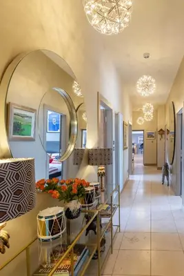 a hallway with a large mirror and a table with flowers at JOIVY Beautiful Penthouse with Terrace & Jacuzzi in Edinburgh