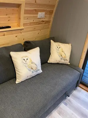 a couch with two pillows on it in a room at Glamping Pods in Milngavie