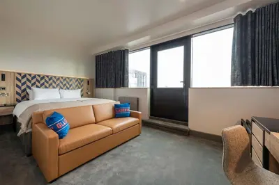 a hotel room with a bed and a couch at Sandman Signature Glasgow Hotel in Glasgow