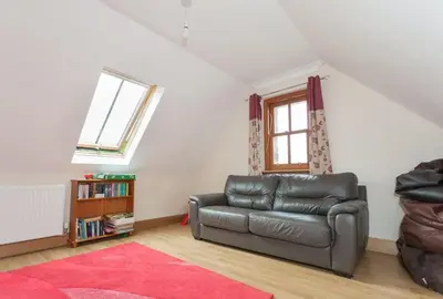 a living room with a leather couch and a window at Appletree Cottage at Williamscraig Holiday Cottages in Linlithgow