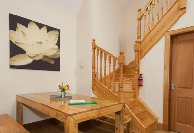 a room with a wooden table and a staircase at Appletree Cottage at Williamscraig Holiday Cottages in Linlithgow