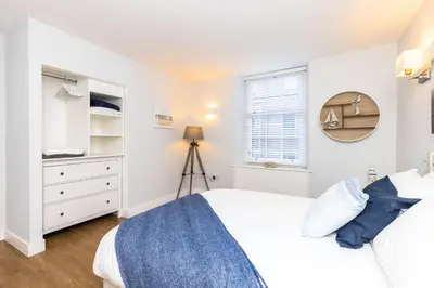 a bedroom with a bed and a dresser and a window at Luxury Modern 3 Bedroom Apartment in City Centre in Edinburgh