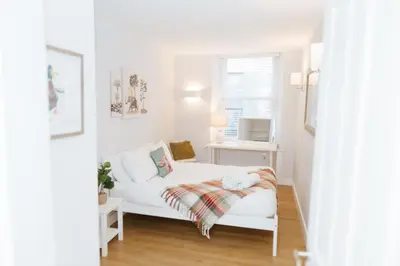 a white bed in a small room with a window at Luxury Modern 3 Bedroom Apartment in City Centre in Edinburgh