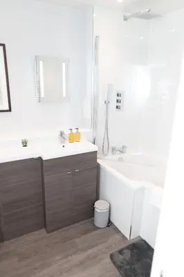 a white bathroom with a tub and a sink at Luxury Modern 3 Bedroom Apartment in City Centre in Edinburgh