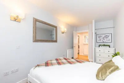 a white bedroom with a bed and a mirror at Luxury Modern 3 Bedroom Apartment in City Centre in Edinburgh