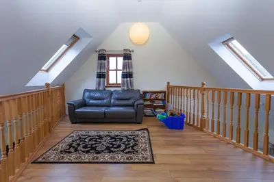 a living room with a couch and a rug at Beech Cottage at Williamscraig Holiday Cottages in Linlithgow