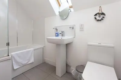 a white bathroom with a sink and a toilet at Beech Cottage at Williamscraig Holiday Cottages in Linlithgow