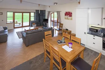 a living room with a table and a couch at Beech Cottage at Williamscraig Holiday Cottages in Linlithgow