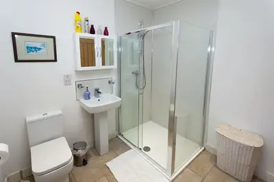 a bathroom with a shower and a toilet and a sink at Laurel Cottage at Williamscraig Holiday Cottages in Linlithgow