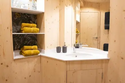 a bathroom with a sink and yellow towels on shelves at Craigmaddie Muir Roundhouse with Hot Tub Romantic, Luxury, Rural Stay for 2 Near Milngavie in Glasgow