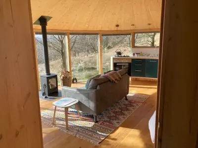 a living room with a couch and a stove at Craigmaddie Muir Roundhouse with Hot Tub Romantic, Luxury, Rural Stay for 2 Near Milngavie in Glasgow