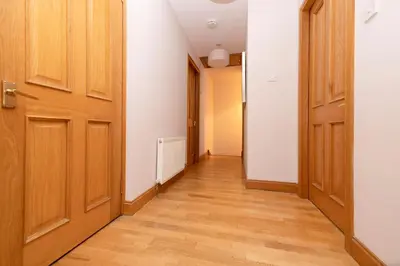 an empty hallway with two doors and wooden floors at JOIVY Bright and Cosy Flat near The Scotland Gallery in Edinburgh