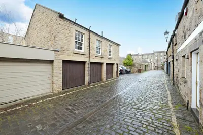 an empty cobblestone street in a city with buildings at JOIVY Bright and Cosy Flat near The Scotland Gallery in Edinburgh