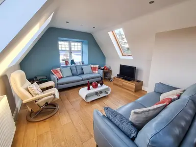 a living room with a couch and a tv at Lochside Apartment in Stronachlachar