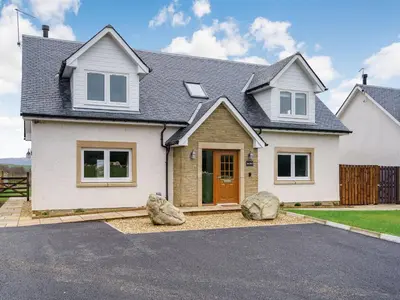 a white house with two large rocks in the driveway at Iora Rua-Uk40006 in Gartmore